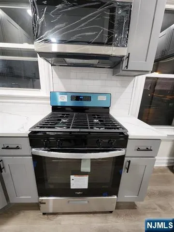 a stove top oven sitting inside of a kitchen