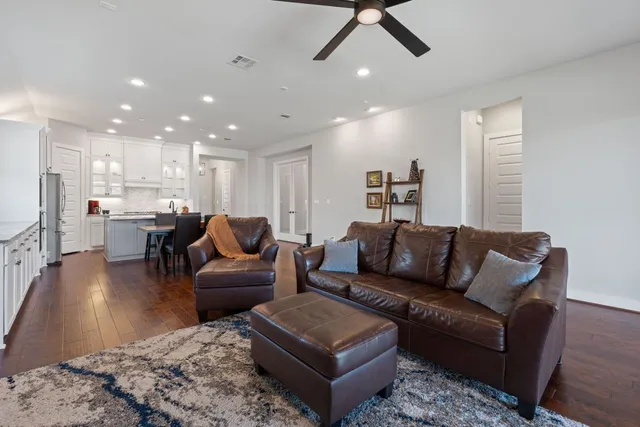 a living room with furniture and a view of kitchen