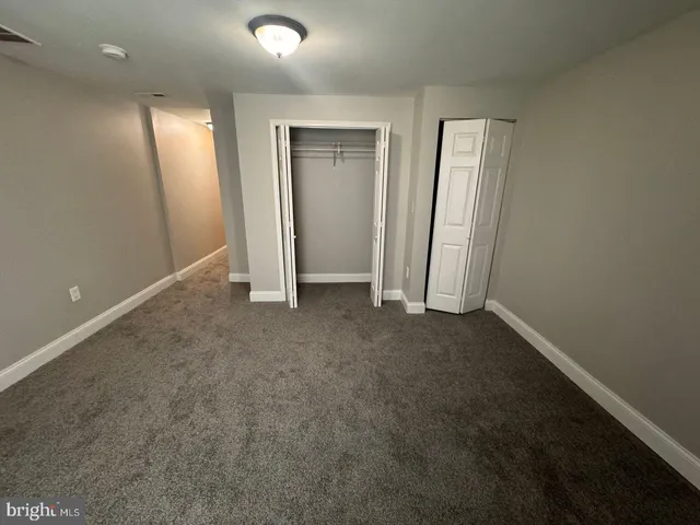 an empty room with closet and wooden floor