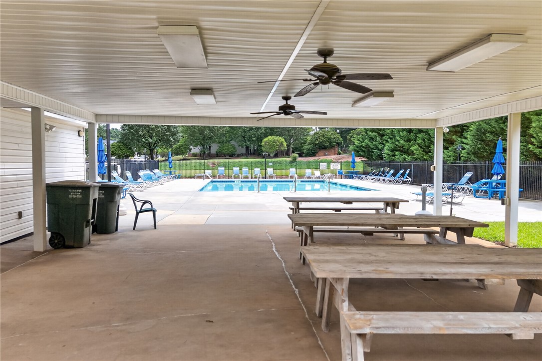 207 Hunters Lane Anderson, SC 29625 - Photo 37 of 46 An inviting covered patio with picnic tables overlooks the community pool, perfect for outdoor gatherings.
