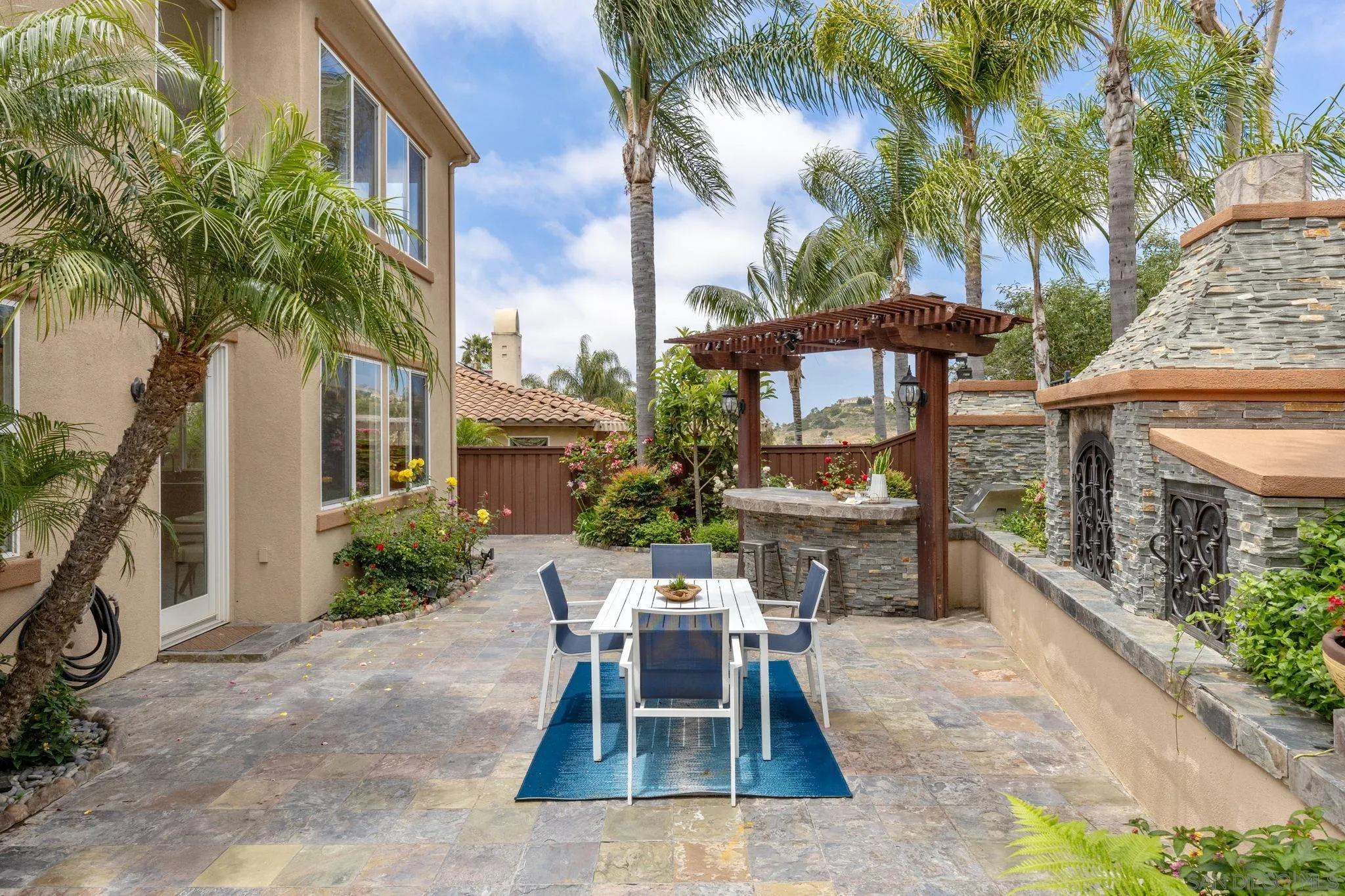 6468 Paseo Cerro Carlsbad, CA 92009 - Photo 29 of 39 a view of a patio with table and chairs potted plants and palm tree