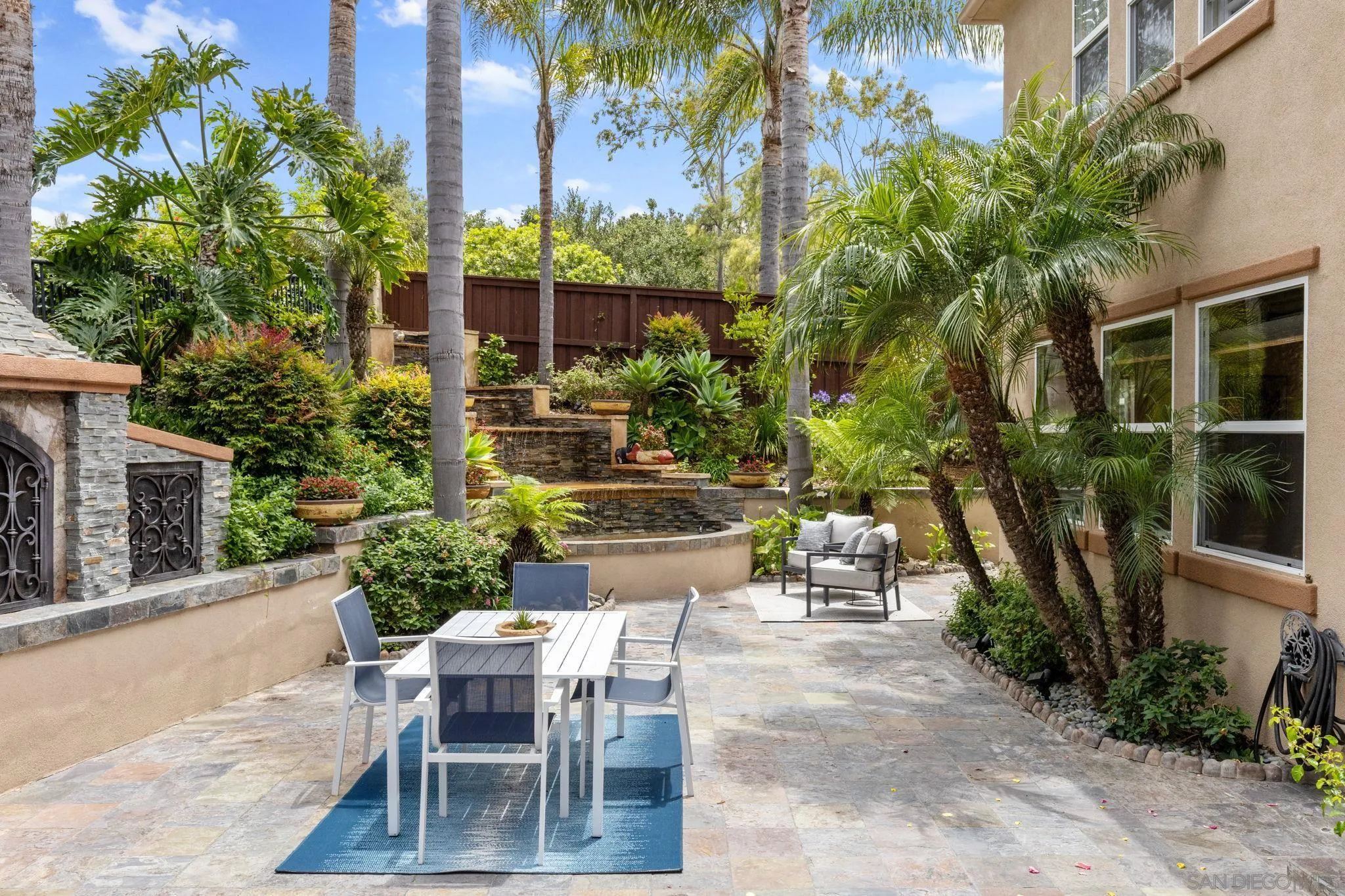 6468 Paseo Cerro Carlsbad, CA 92009 - Photo 30 of 39 a view of a patio with table and chairs potted plants and palm tree