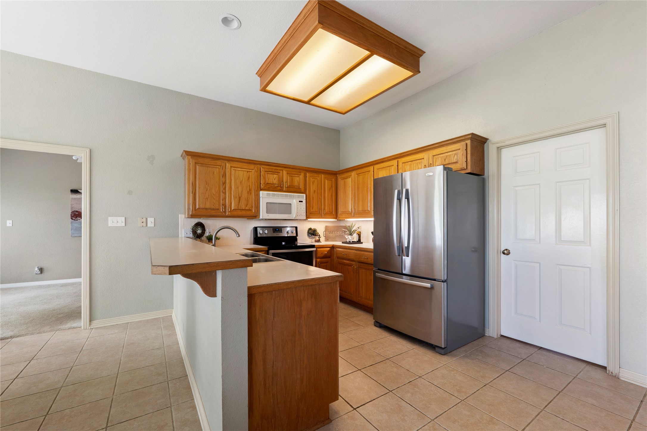 1005 East Buttercup Road Taylor, TX 76574 - Photo 18 of 38 a kitchen with stainless steel appliances granite countertop a refrigerator a stove and a sink