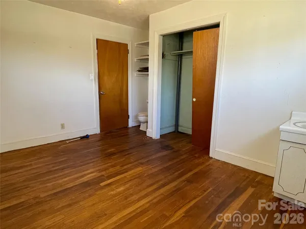 a view of a room with wooden floor and bathroom