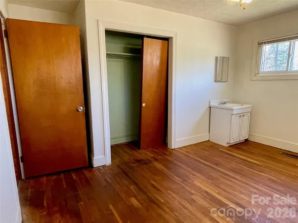 an empty room with wooden floor and closet