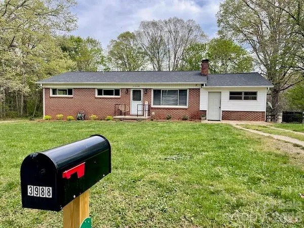 a view of a house with a yard and sitting area