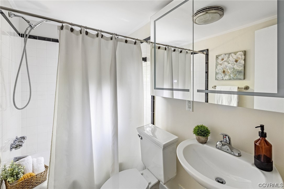 8621 Fieldcrest Road Richmond, VA 23235 - Photo 16 of 44 a bathroom with a sink a toilet and shower curtain