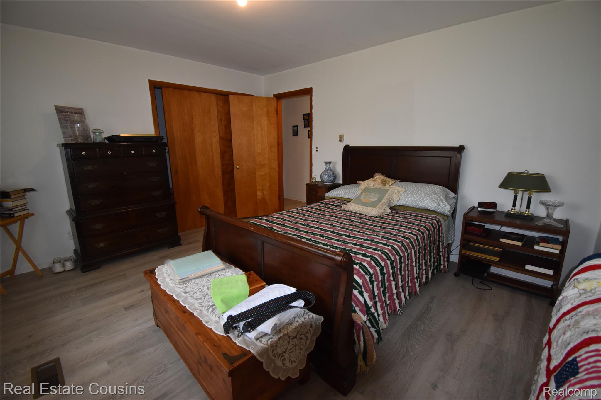 2247 Johnson Mill Road North Branch, MI 48461 - Photo 14 of 22 Bedroom featuring wood-finish flooring, light-toned walls, and a wood-paneled closet with sliding doors