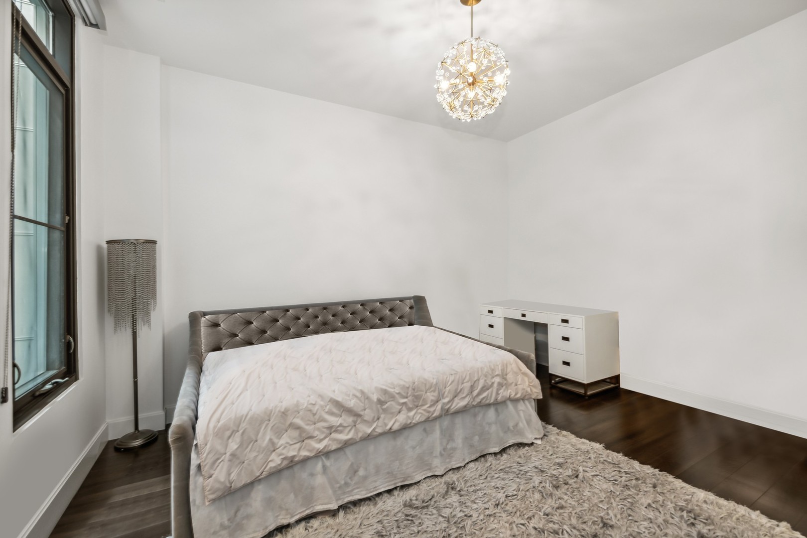 40 North Carpenter Street, Unit 4S Chicago, IL 60607 - Photo 18 of 25 a bedroom with a bed and a chandelier
