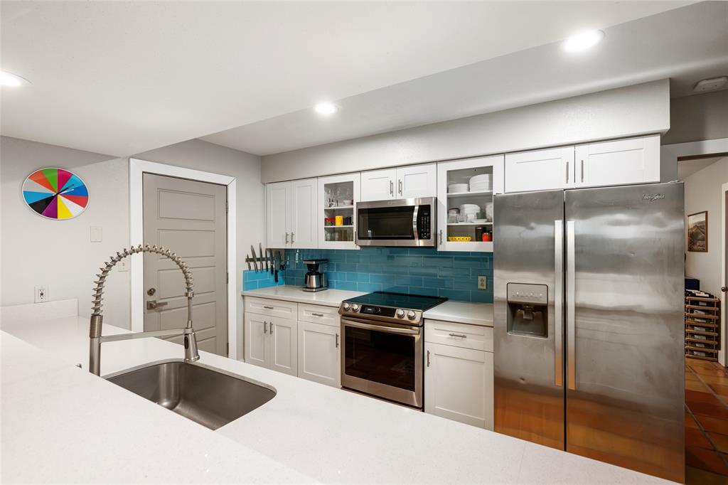 2210 Red Fox Road Austin, TX 78734 - Photo 13 of 40 A well-appointed kitchen showcasing pristine white cabinetry and sleek stainless steel appliances.