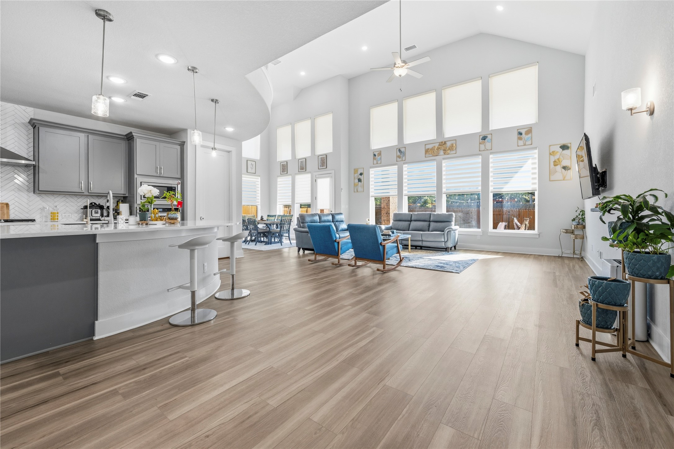 105 Autumn Oak Way Georgetown, TX 78628 - Photo 7 of 40 Open-concept living space with vaulted ceilings, wood-finish flooring, and a kitchen island featuring pendant lighting