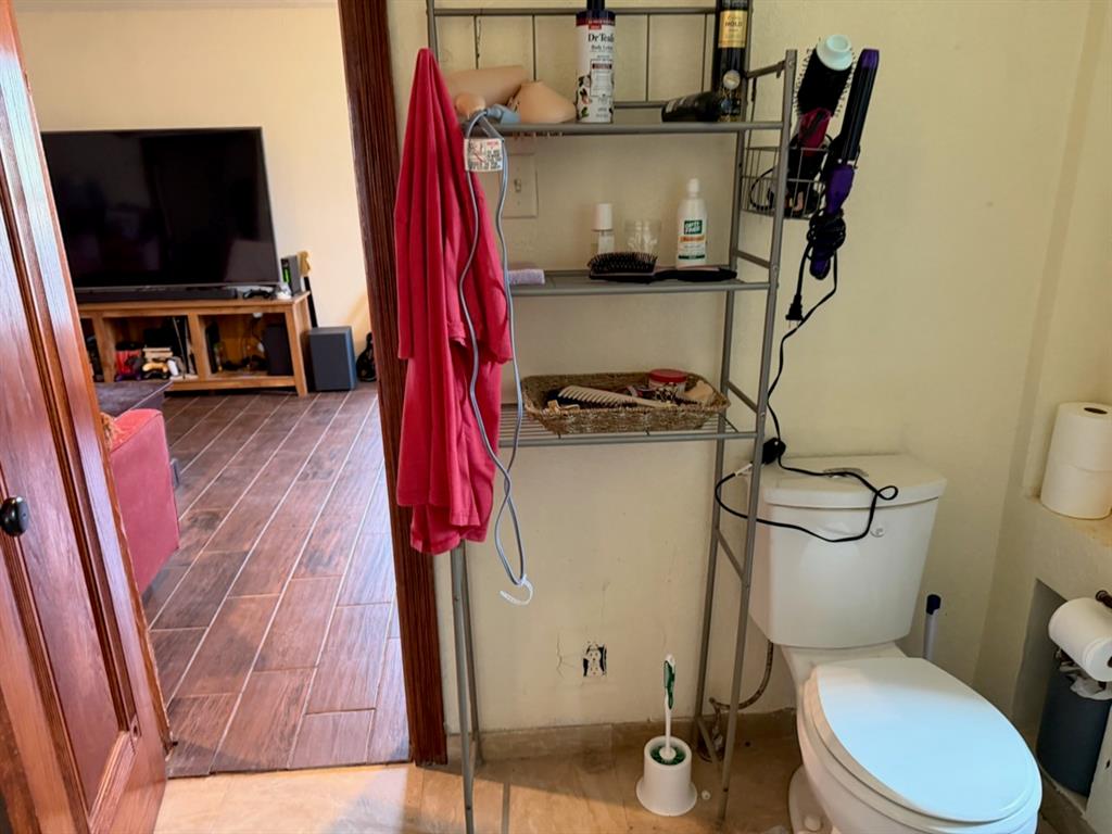 4050 Old Anson Road Abilene, TX 79601 - Photo 28 of 40 a bathroom with a toilet a sink and a mirror