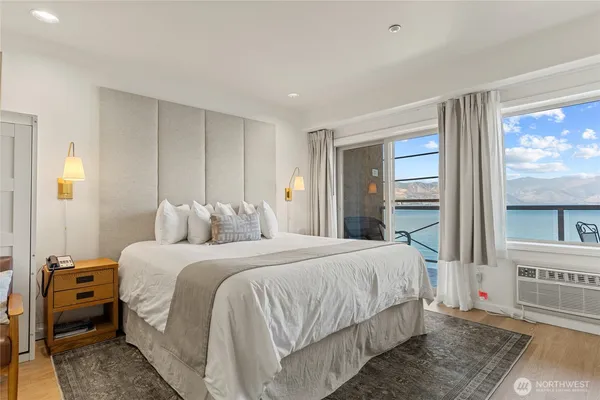 a bedroom with a bed and a painting on the wall