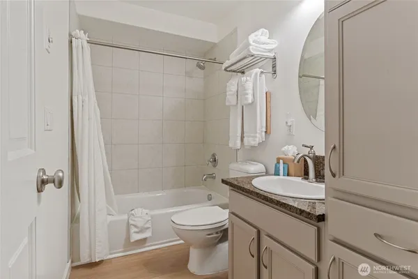 a bathroom with a granite countertop sink a toilet and shower