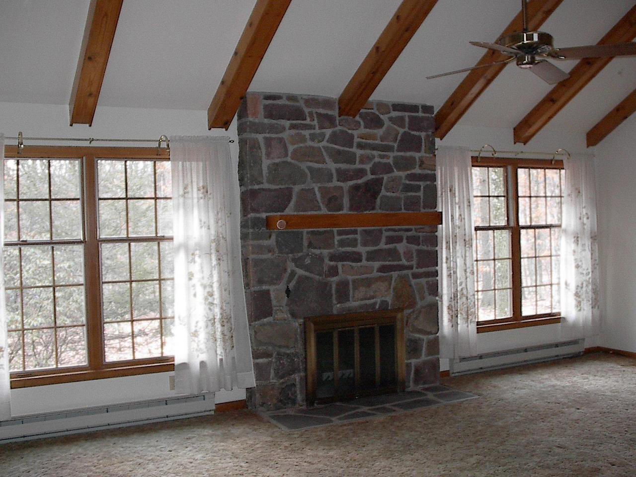 406 Cays Road Stroudsburg, PA 18360 - Photo 2 of 4 an empty room with a fireplace and windows