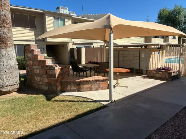 a patio with table and chairs and potted plants