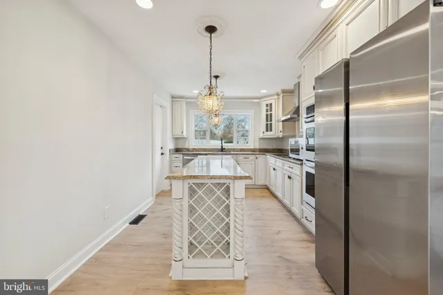 a kitchen with stainless steel appliances granite countertop a sink a oven a stove and a refrigerator