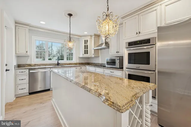 a large kitchen with granite countertop a sink and cabinets