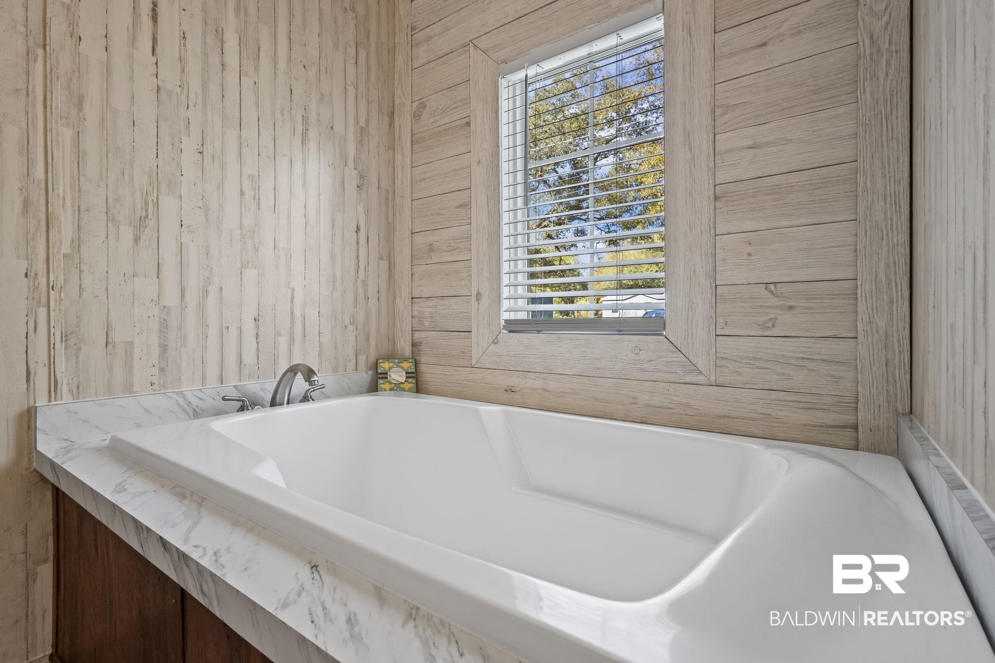 12960 7th Street Lillian, AL 36549 - Photo 17 of 25 Full bathroom featuring wood walls, a bathtub, and a healthy amount of sunlight