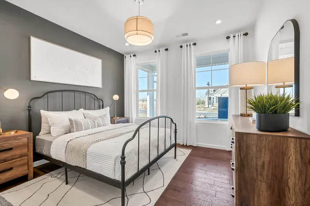 a bedroom with bed and wooden floor