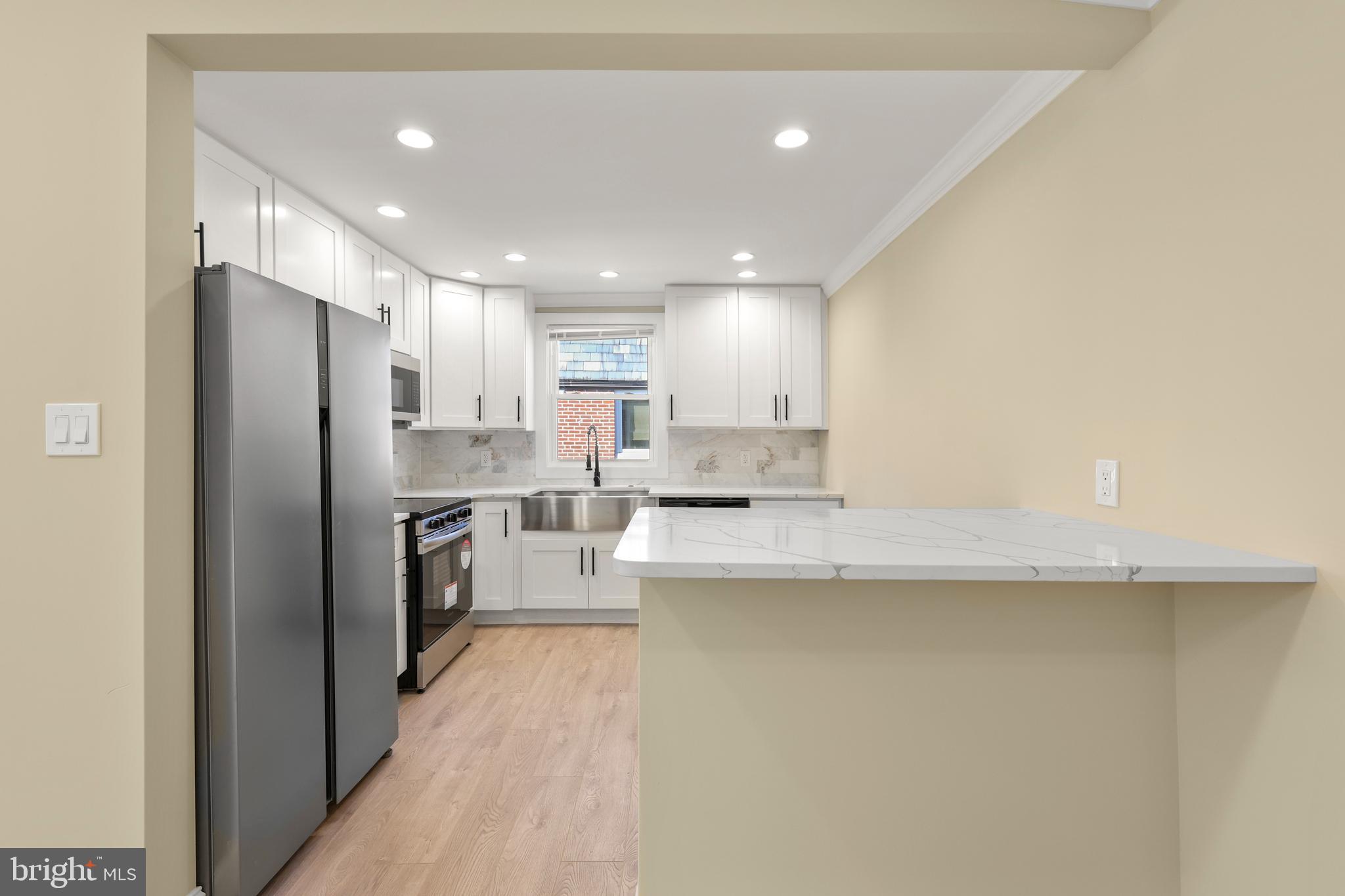 602 Wanamaker Road Jenkintown, PA 19046 - Photo 8 of 39 a kitchen with a refrigerator a sink and white cabinets