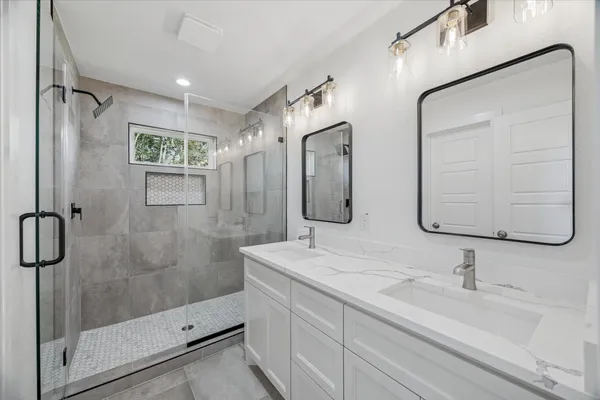 a bathroom with a shower sink and mirror