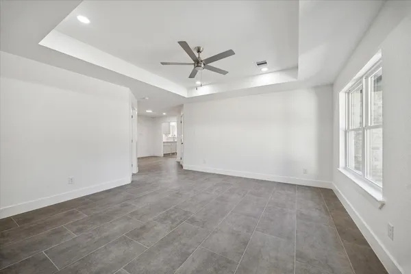 an empty room with windows and fan