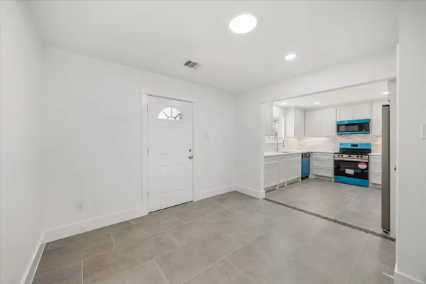 a view of a kitchen with refrigerator and a stove