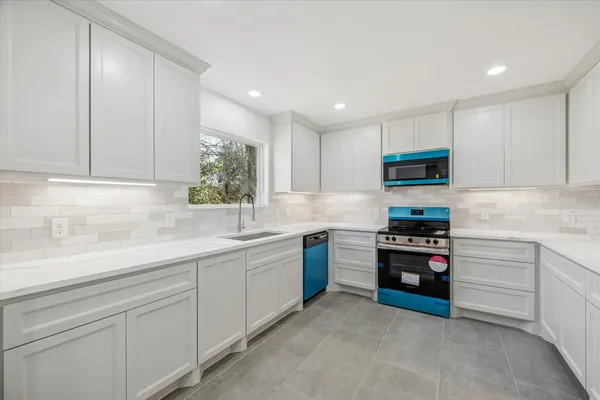 a kitchen with stainless steel appliances granite countertop a sink and a stove