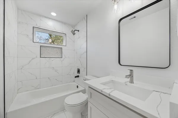 a bathroom with a granite countertop sink toilet and shower