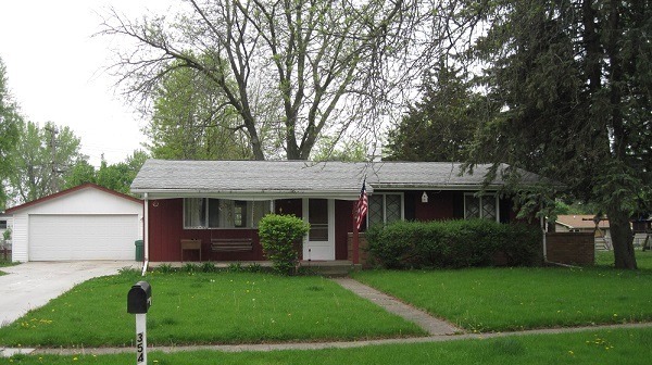 354 Cleveland Avenue Rochelle, IL 61068 - Photo 1 of 22 a front view of a house with a garden and plants
