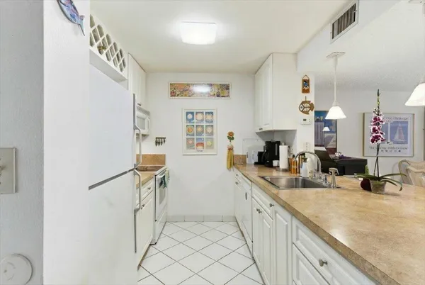 a kitchen with stainless steel appliances granite countertop a sink and a refrigerator