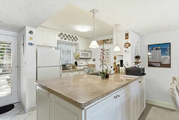 a kitchen with stainless steel appliances granite countertop a sink refrigerator and cabinets