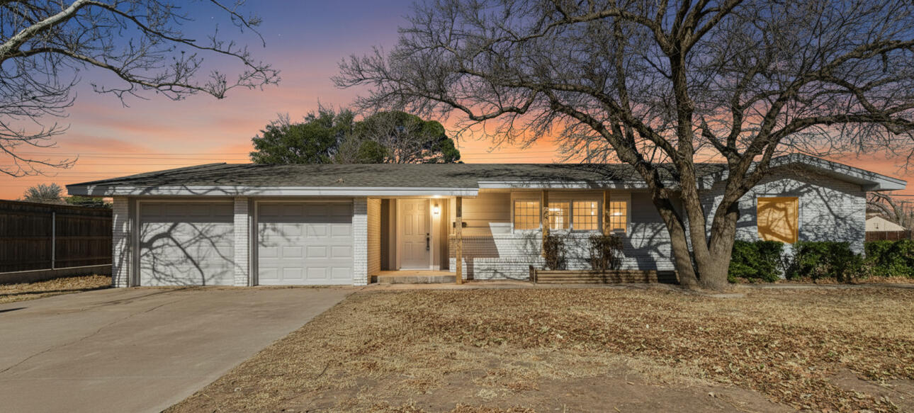 front view of a house with a yard and garage