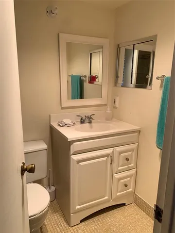 a living room with stainless steel appliances furniture and a kitchen view
