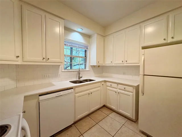 a kitchen with white cabinets and white appliances