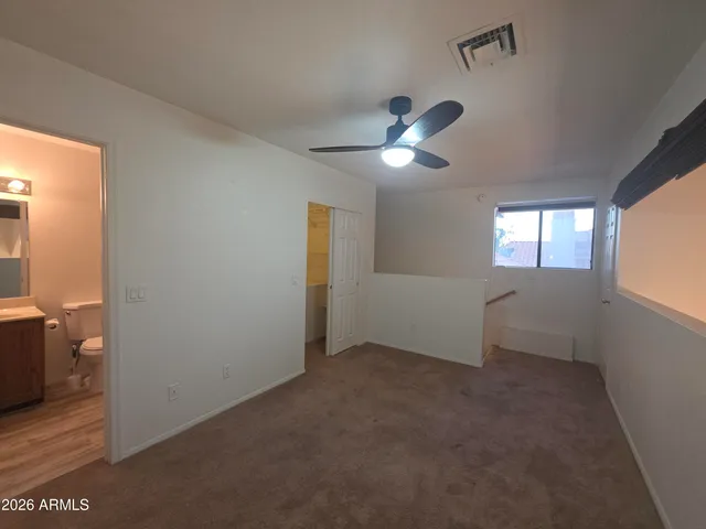 a view of empty room with window and ceiling fan