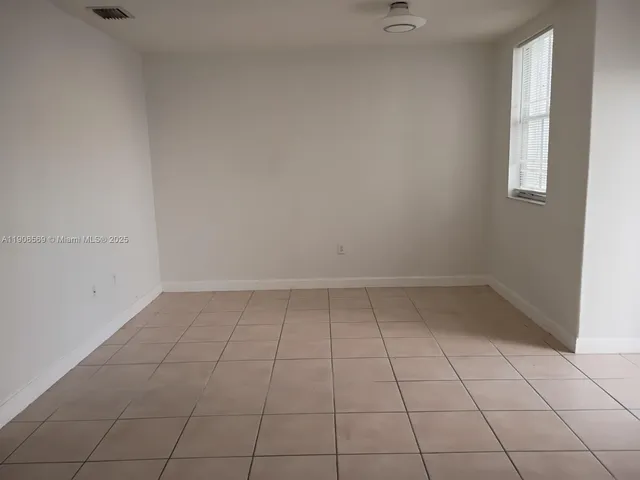 an empty room with white walls and tiles