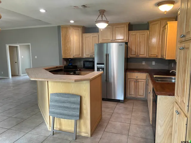 a kitchen with stainless steel appliances granite countertop a sink a refrigerator and a stove