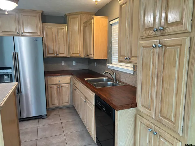 a kitchen with granite countertop a refrigerator stove and sink