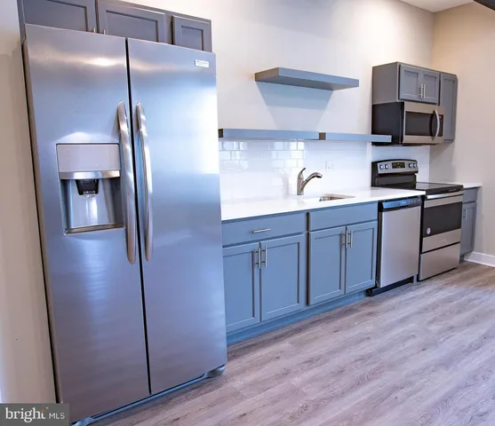 a kitchen with stainless steel appliances granite countertop a refrigerator and a sink