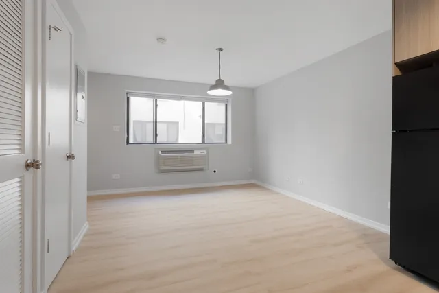 an empty room with windows and cabinet