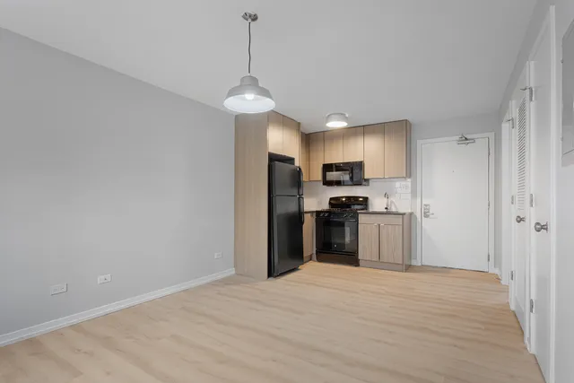 a kitchen with stainless steel appliances granite countertop a refrigerator a oven a sink dishwasher and a refrigerator with wooden floor