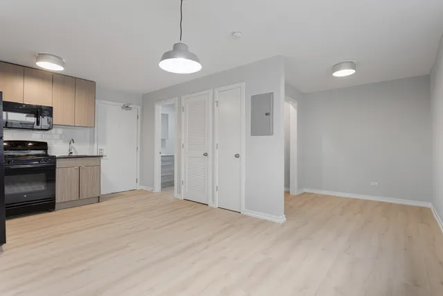 a view of a kitchen with a sink and dishwasher a refrigerator with wooden floor