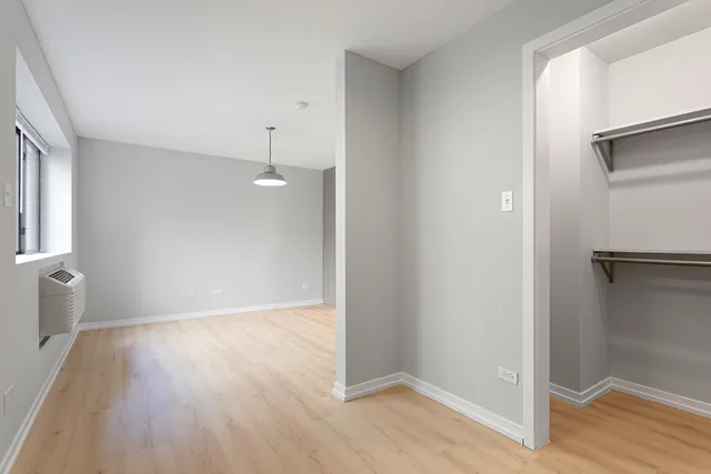 a view of a room with wooden floor and a window