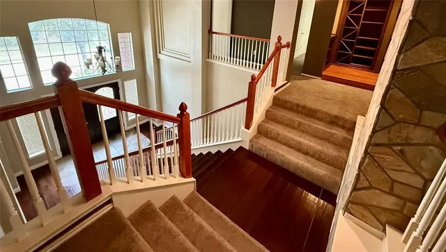 a view of hallway with window and wooden floor