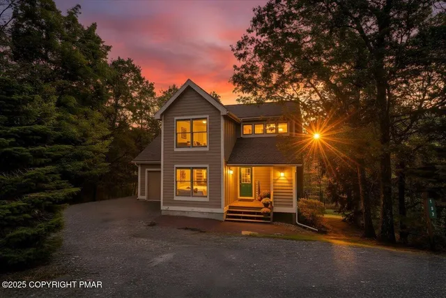 a view of a big house with a large windows and large tree