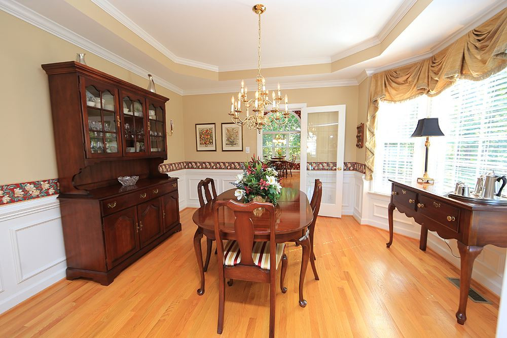 2516 Wertherson Lane Raleigh, NC 27613 - Photo 7 of 25 Formal dining room w/ tray ceiling, bay window, wainscoting, and hardwood floors. Dining Room
