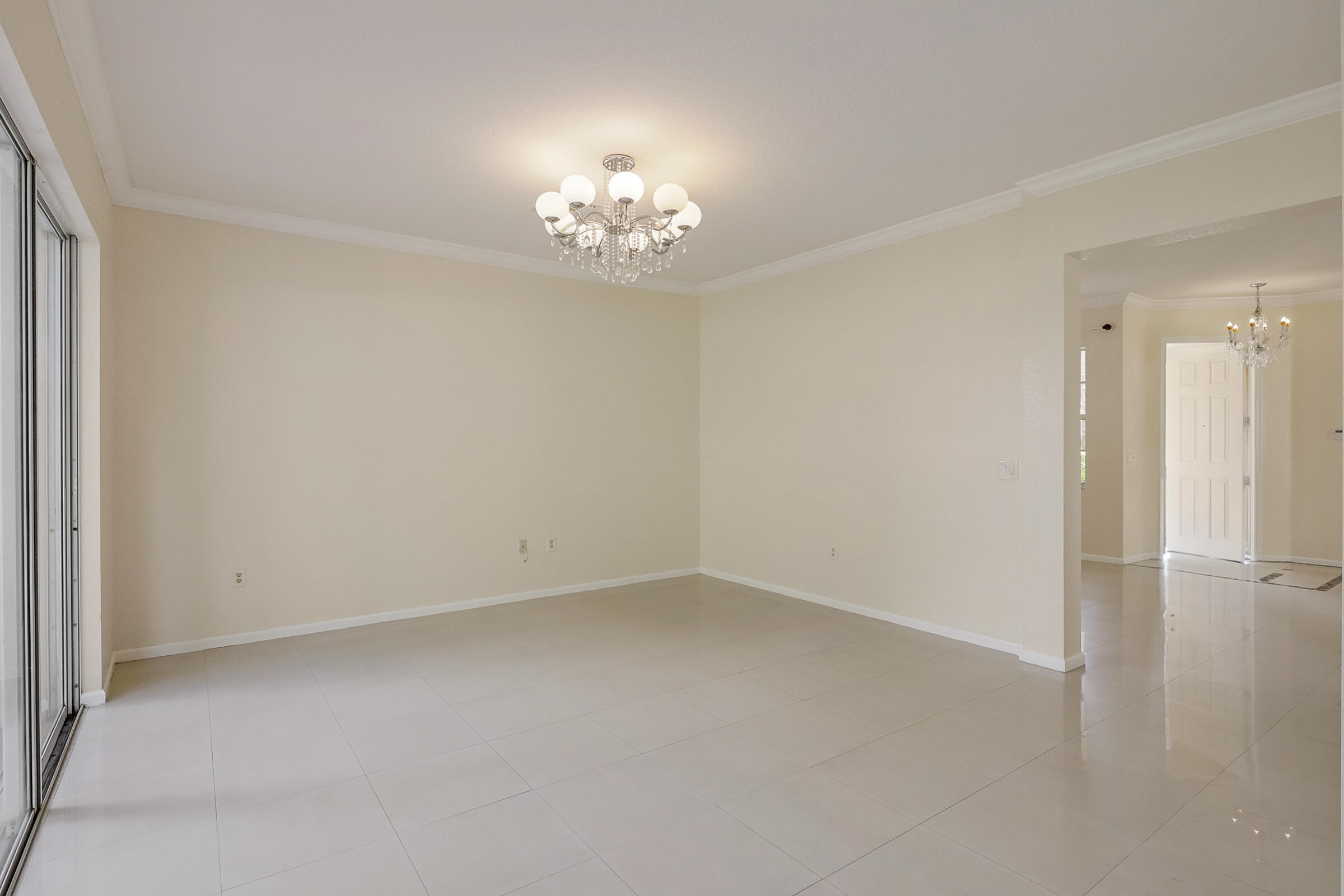 10208 White Water Lily Way Boynton Beach, FL 33437 - Photo 11 of 38 an empty room with a chandelier fan and windows