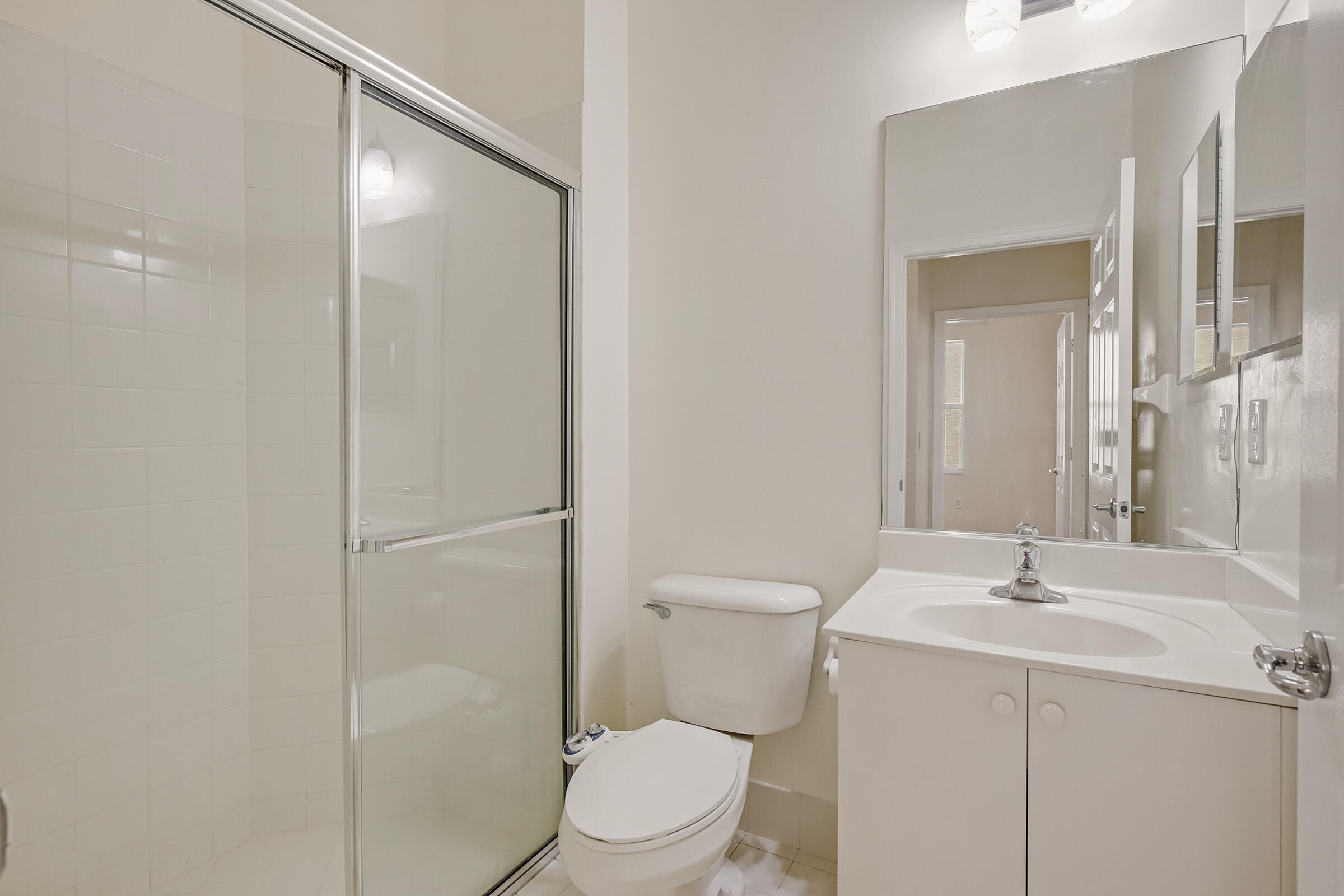 10208 White Water Lily Way Boynton Beach, FL 33437 - Photo 18 of 38 a bathroom with a toilet sink vanity and mirror